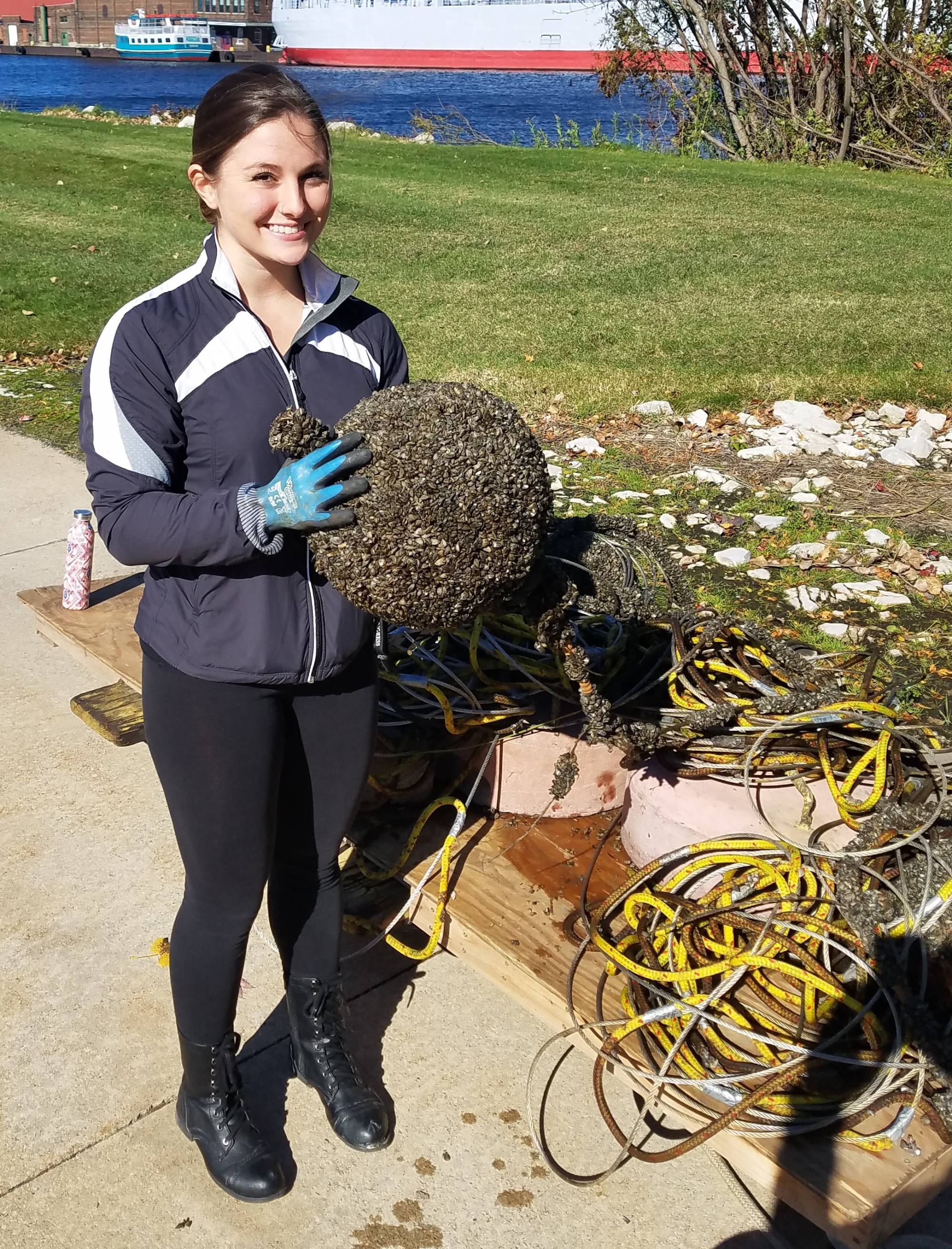 Jasmine Mancuso holding a mussel covered buoy